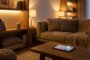 Modernes Wohnzimmer mit smarter Beleuchtung und Sprachassistent in der Abenddämmerung